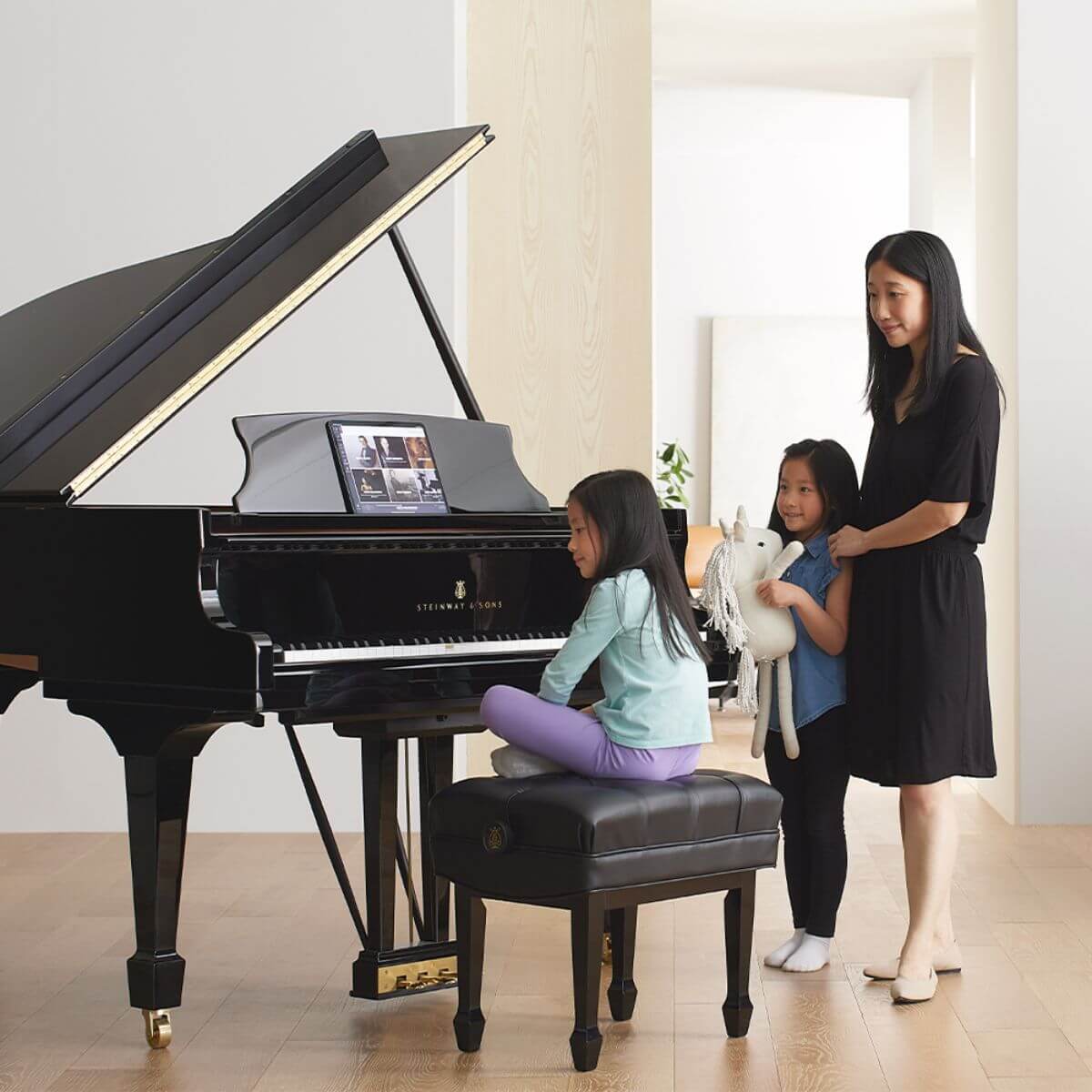 Mother with children using the Steinway pianos