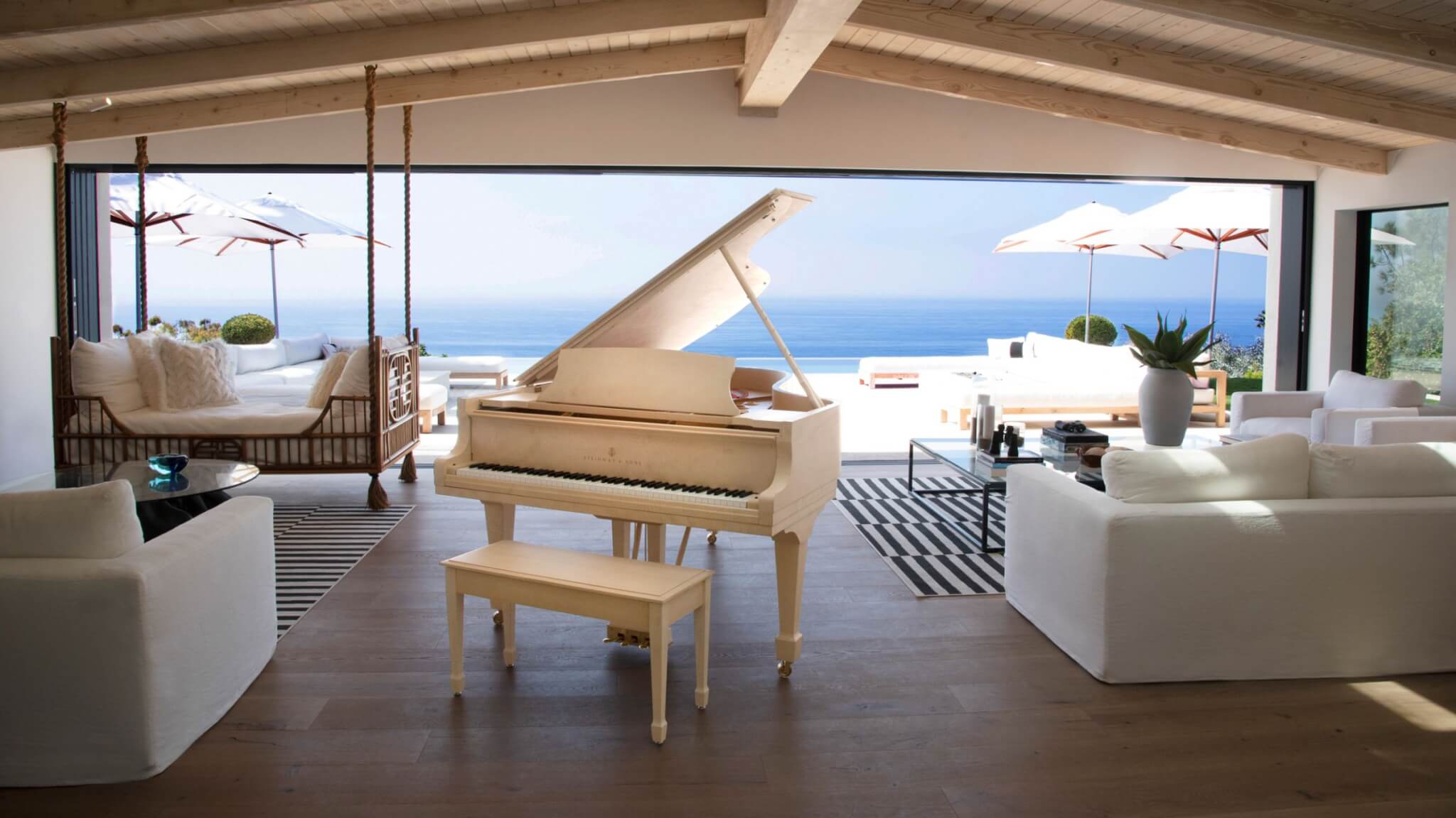 Steinway Crown Jewel placed in the foreground of exotic living room with view of beach in the background